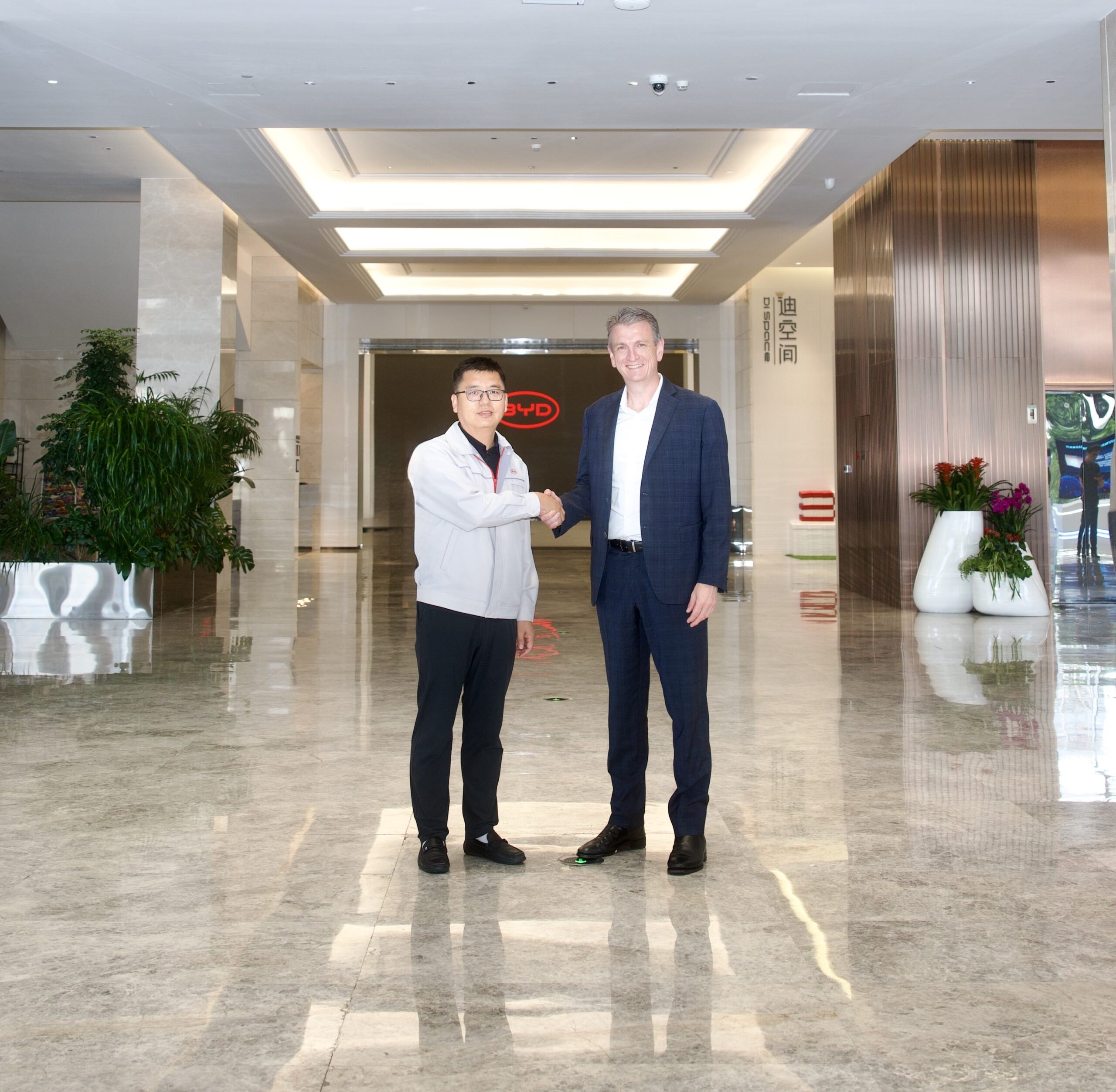Mr Wang Ping and Mr Scott Wharton shaking hands at the BYD facility in Shenzhen.